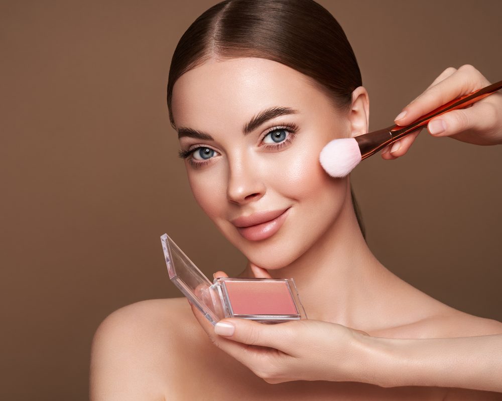 Blush being applied with a makeup brush